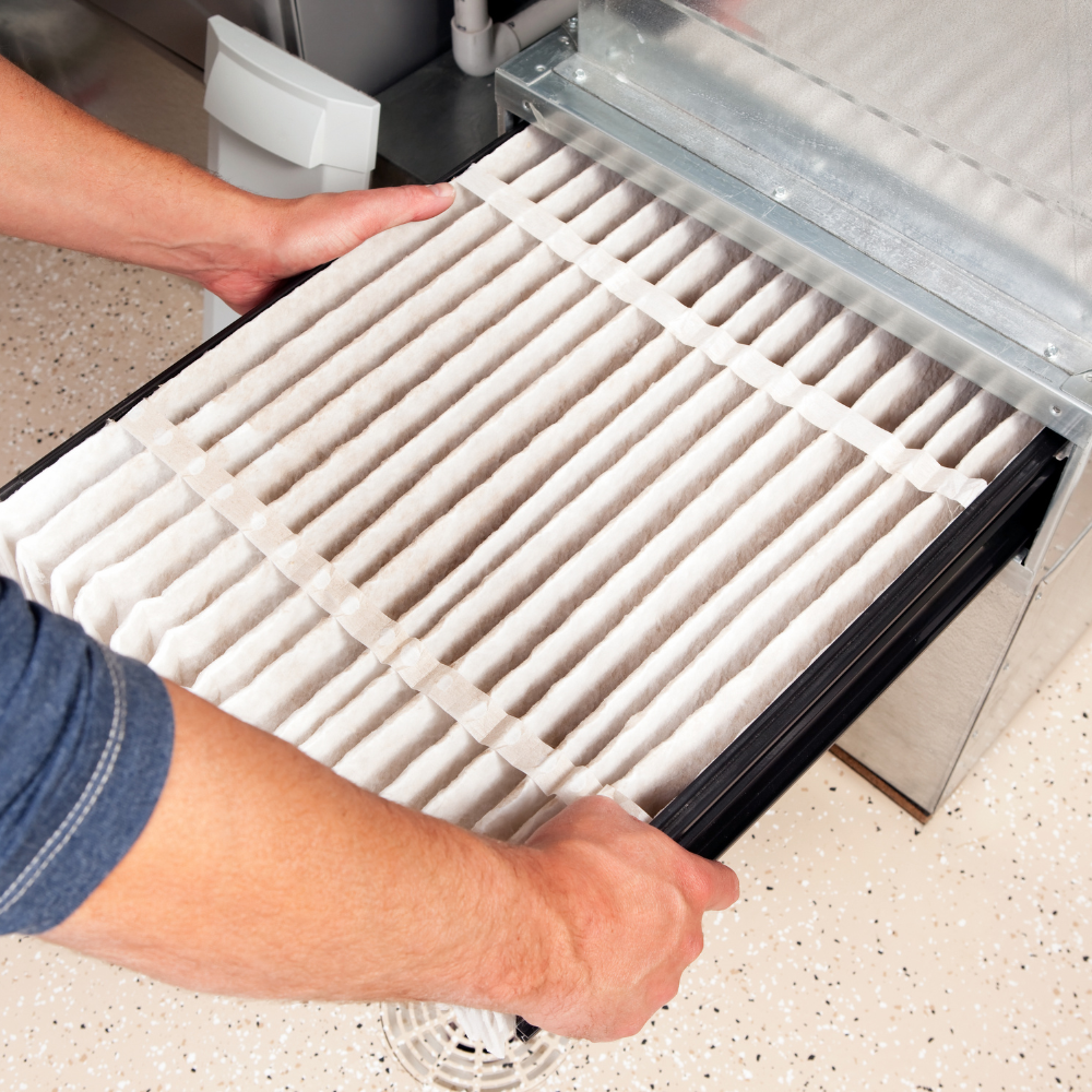 a worker changing the filter in a furnace
