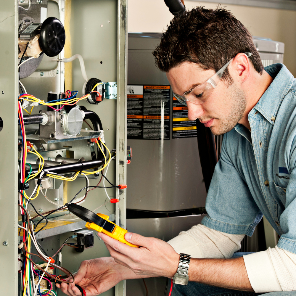 an HVAC technician checking wires inside a furnace